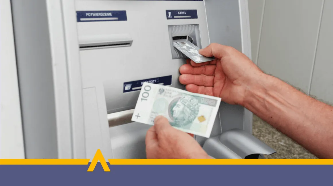 Wypłata gotówki z bankomatu – banknot 100 zł i karta płatnicza
